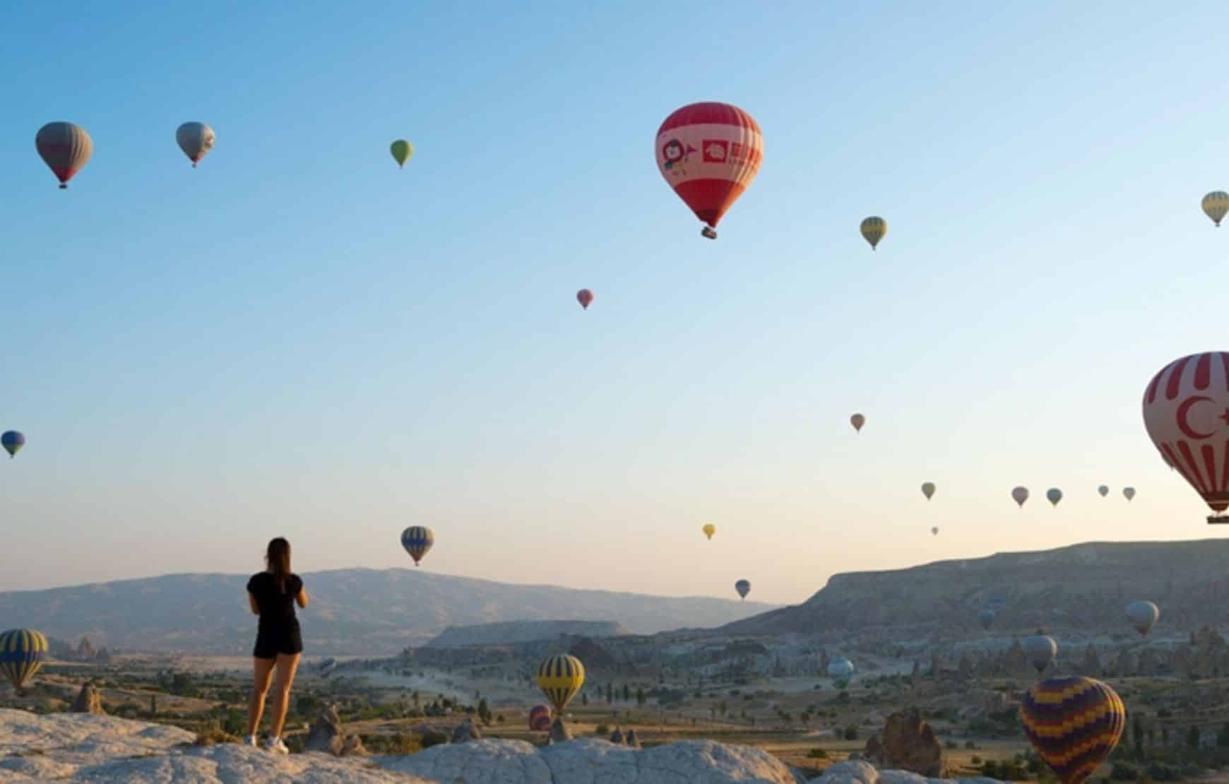 a women watching hot air balloons at Cappadocia Balloon Watching Tour