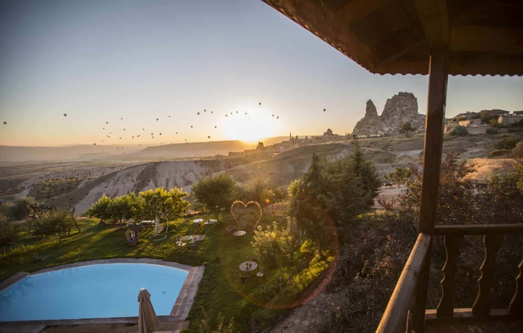 morning hot air balloons view at You glass-ceiling room at Karlik Evi Cappadocia